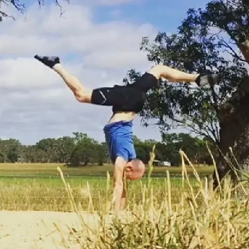 Tom Sharp doing a handstand in a field